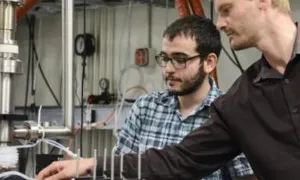 Two men working on a machine. 