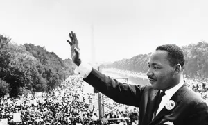 Dr. Martin Luther King, Jr. waving to a crowd at the Capitol Building.  