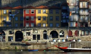 brightly painted three-story buildings line a rocky seaside cliff