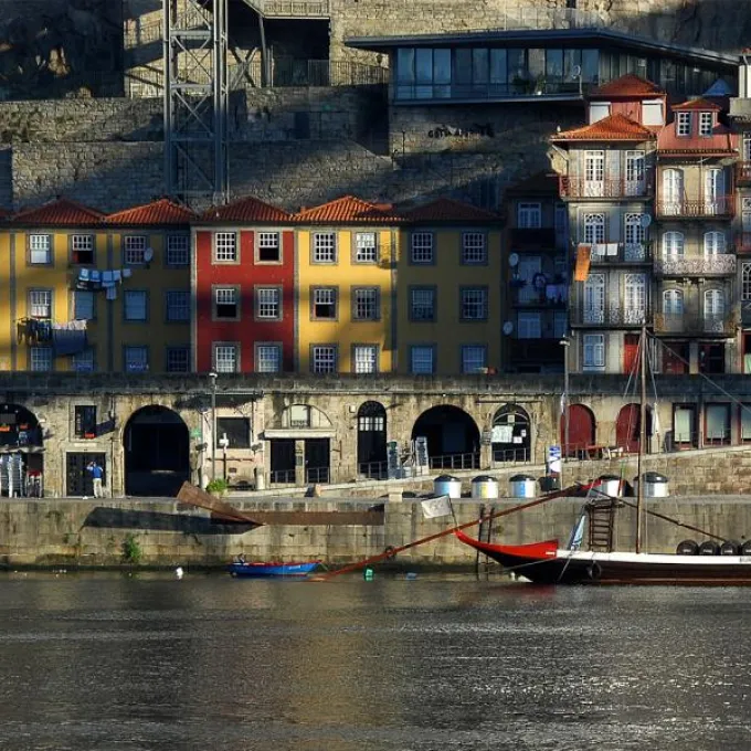 brightly painted three-story buildings line a rocky seaside cliff